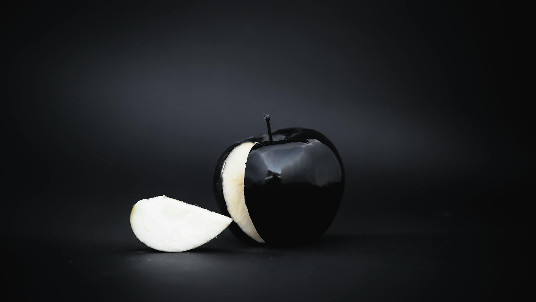 black apple with slice cut out